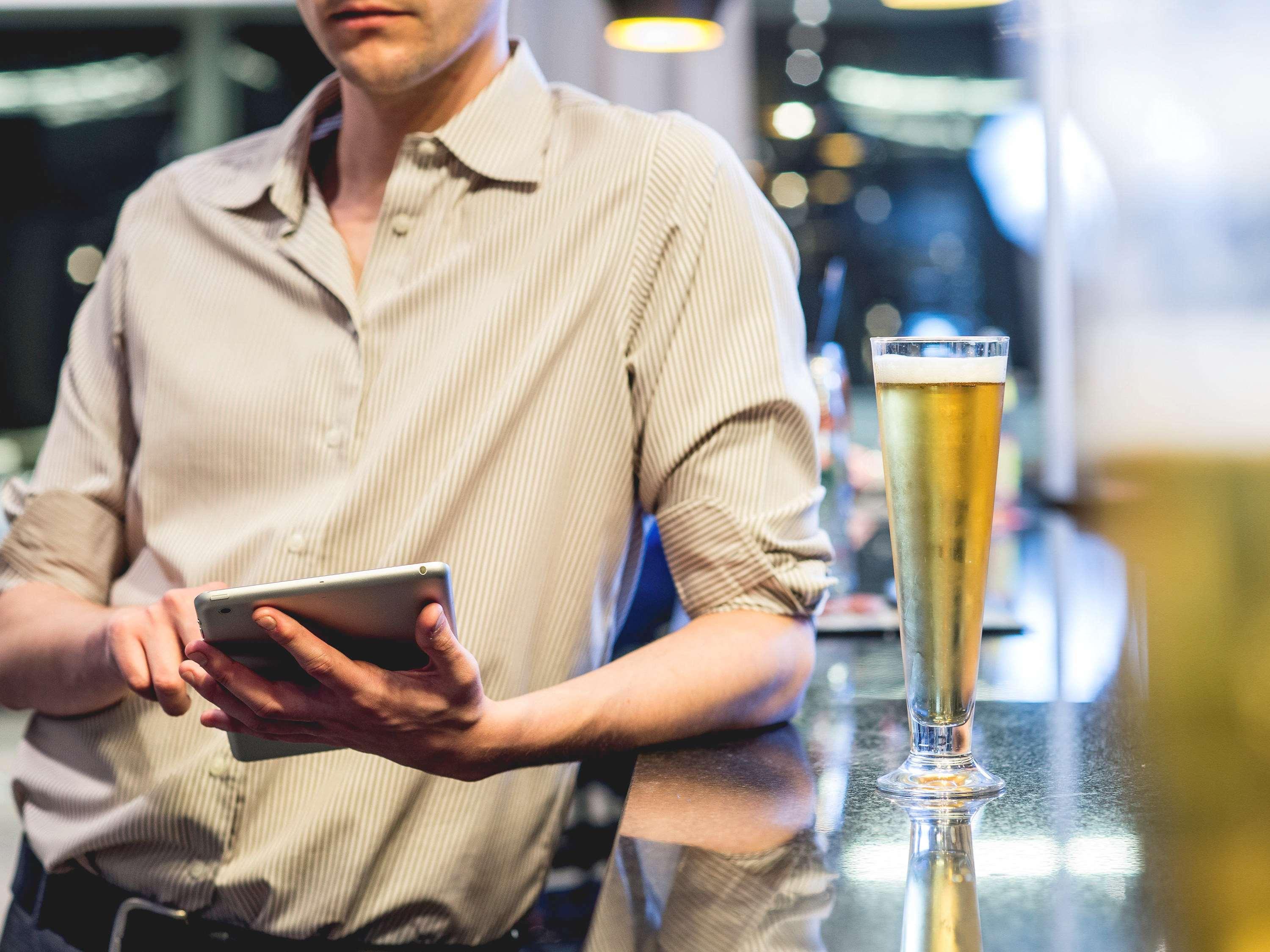 Pullman Santiago Vitacura Bagian luar foto A bartender using a tablet computer