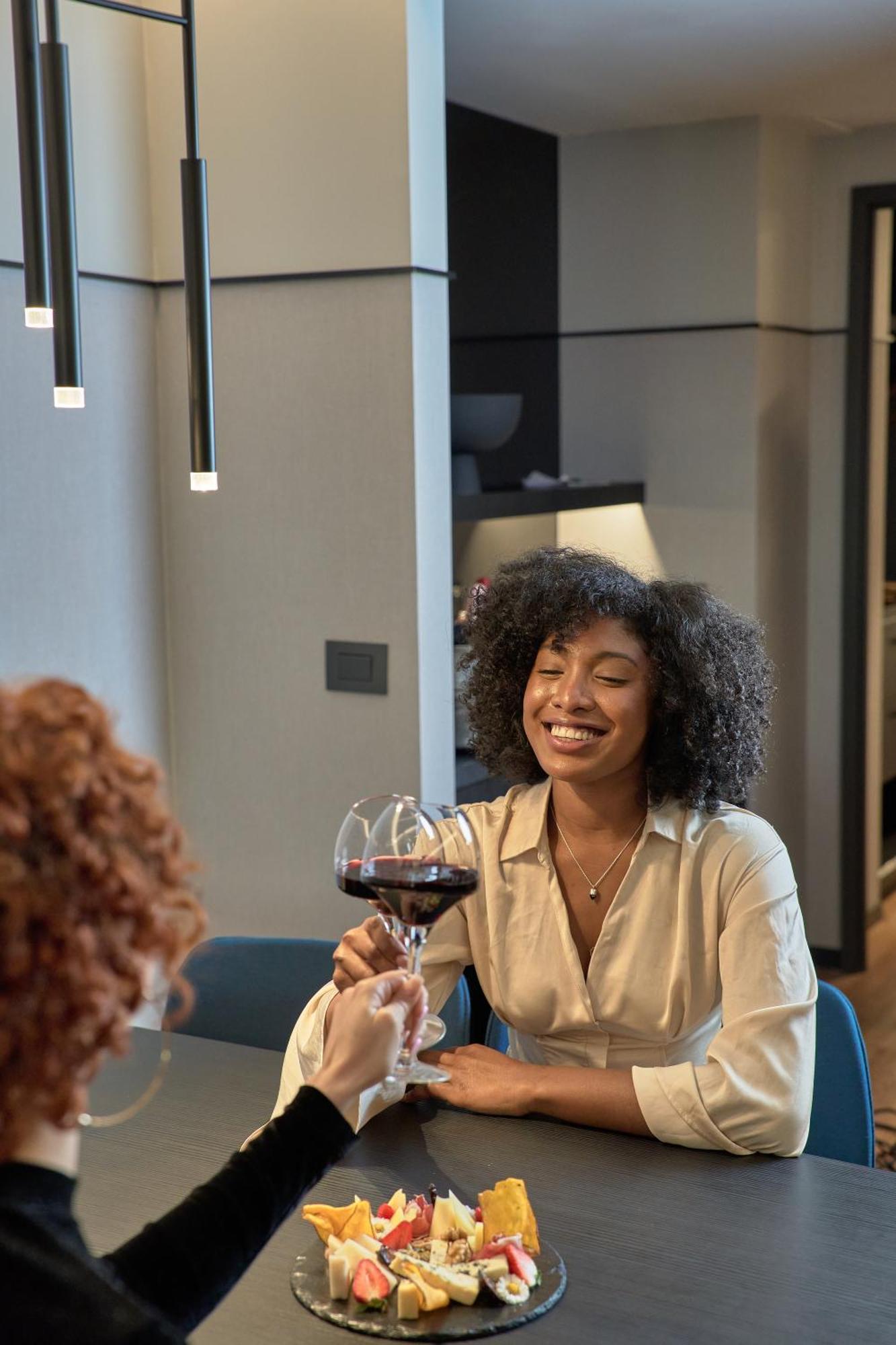 Pullman Santiago Vitacura Bagian luar foto A woman with a glass of wine